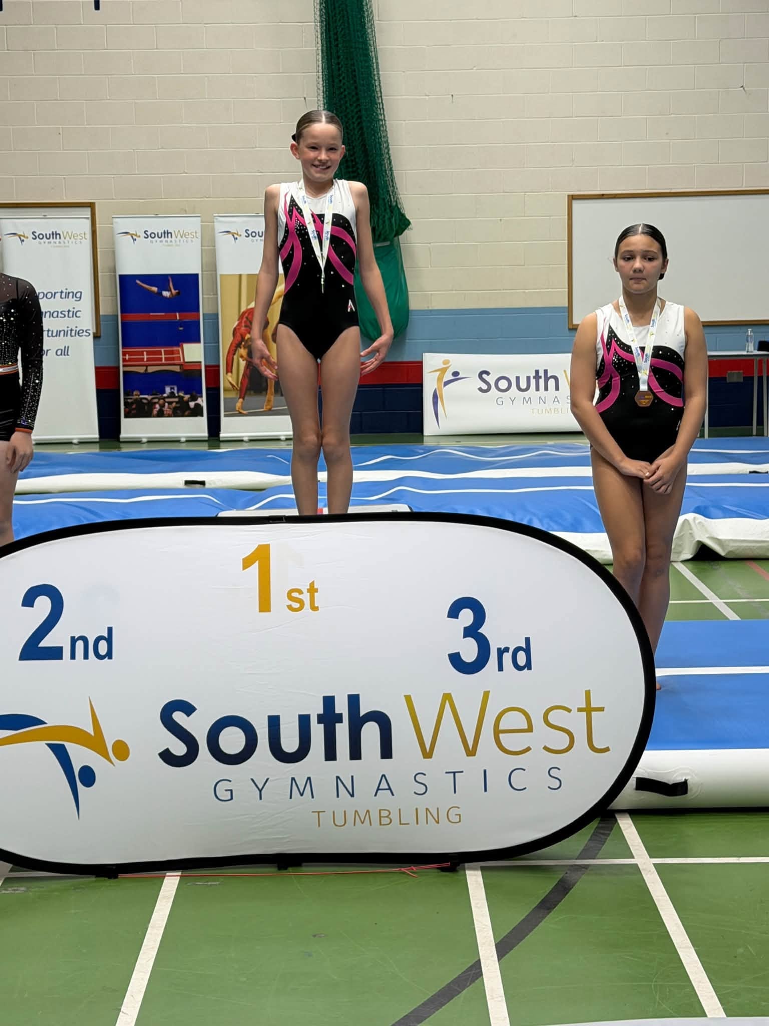 Two gymnasts on podium at South West Tumbling competition