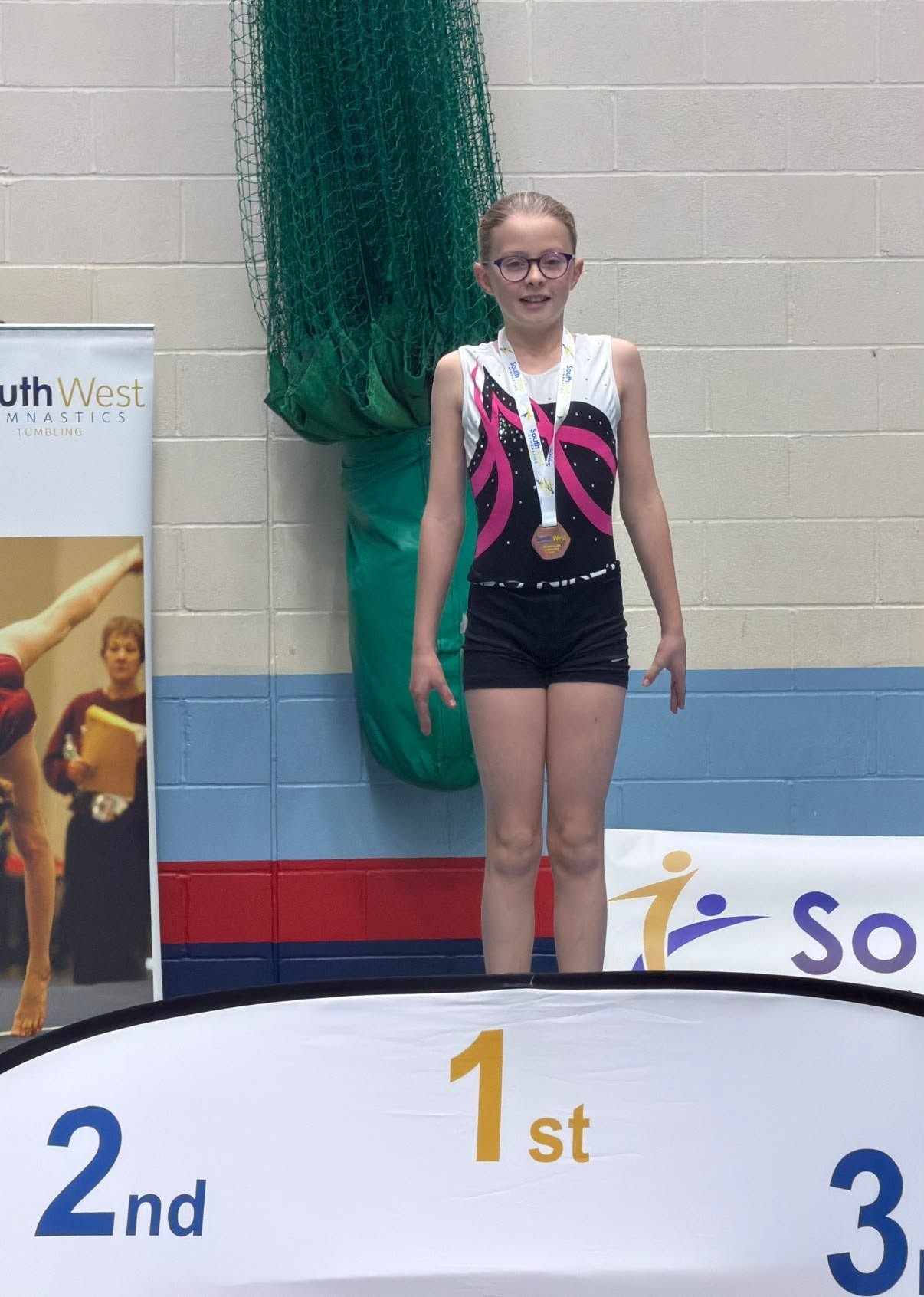 Gymnast on 1st place podium at South West Tumbling competition